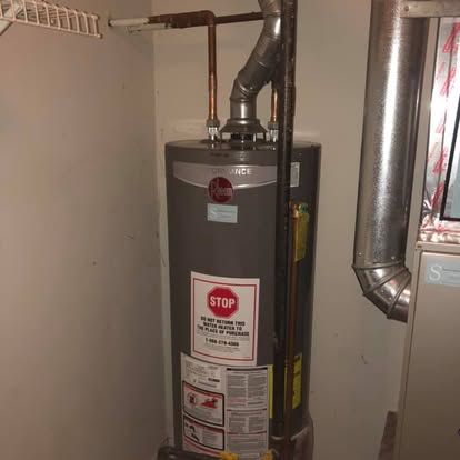 A freshly installed gas water heater with new venting and copper lines.
